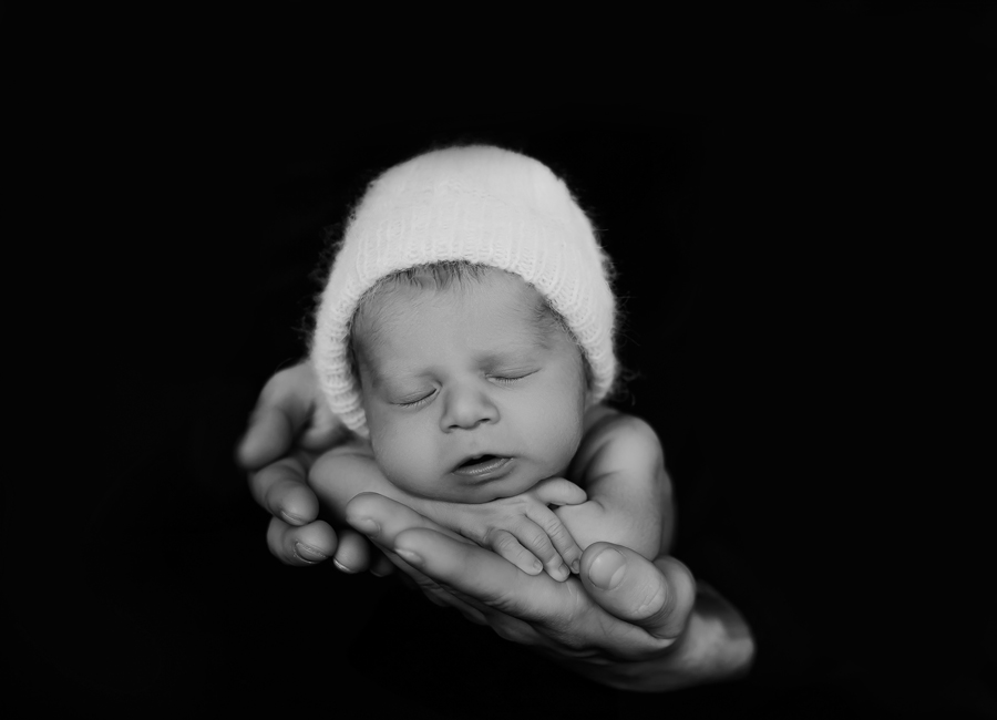 ein Neugeborenes in Papas Händen Fotoshooting München